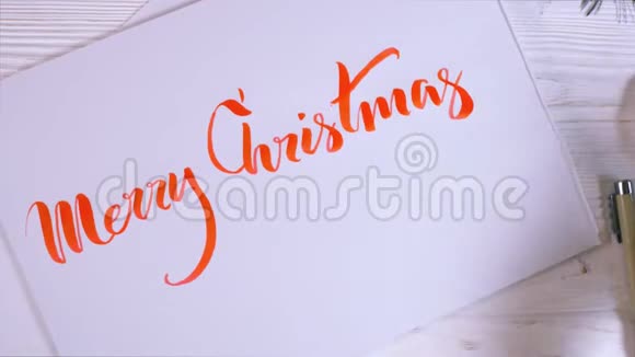 恭喜你圣诞快乐书法家在白牌上用红墨水写字书法装饰字体艺术视频的预览图
