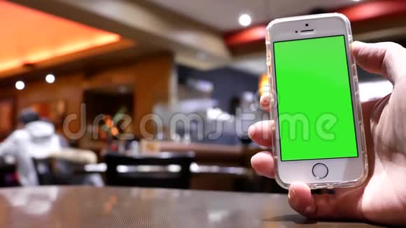 绿色屏幕手机与模糊的人吃食物和聊天的运动视频的预览图