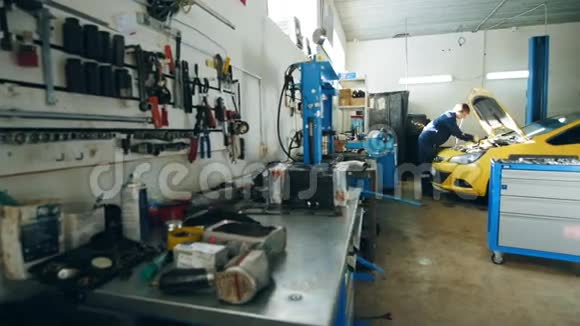 小型汽车车库汽车修理工检查引擎盖黄色汽车视频的预览图