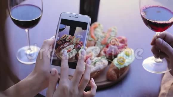 餐饮拍照女人看手机屏幕上的照片视频的预览图