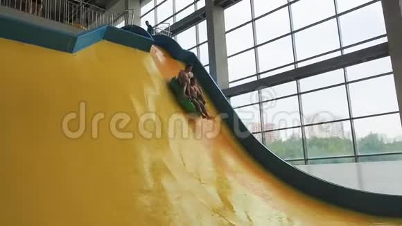 在水上公园里玩极限滑梯朋友们玩得开心在五颜六色的滑梯上滑下来视频的预览图