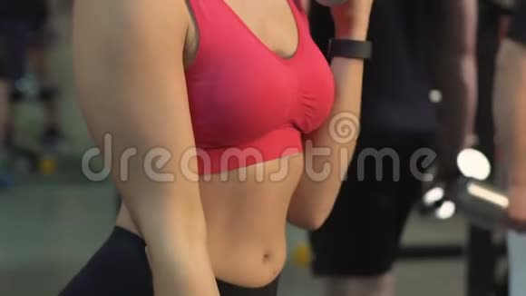 运动俱乐部中漂亮苗条的女性举起哑铃活跃生活健身视频的预览图