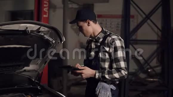 汽车服务技术人员使用数字平板电脑检查车辆内部视频的预览图