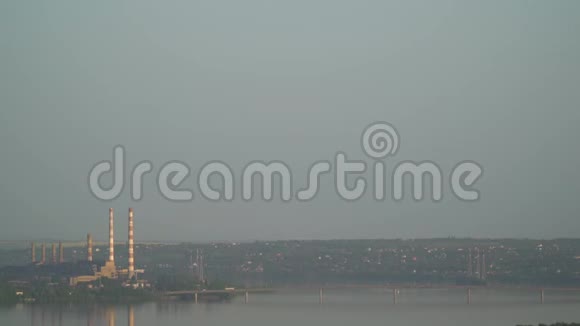 从高处向一座巨大的工厂和一座横跨河流的桥梁拍摄全景视频的预览图