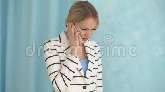 一个穿着条纹夹克打电话的惊恐少女视频的预览图