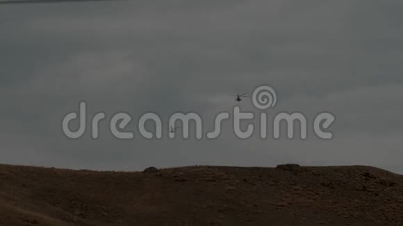 两架直升机飞过山丘向地平线飞去视频的预览图