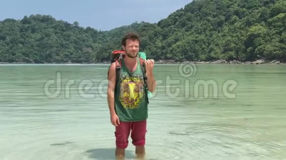 在蔚蓝热带泻湖的温水中游客背包在摇床上玩耍的快乐徒步旅行者视频的预览图