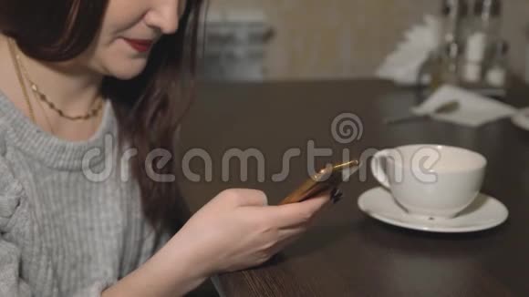 年轻女子坐在咖啡馆里打电话喝茶视频的预览图