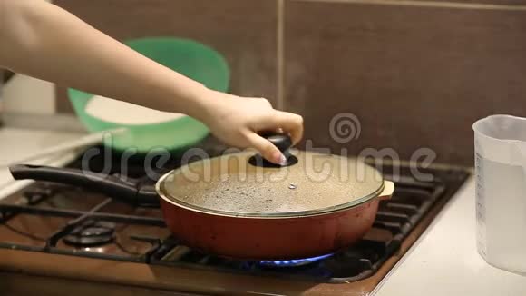 家庭主妇把米饭加了烤肉在厨房的煤气炉上煮了冒口饭视频的预览图