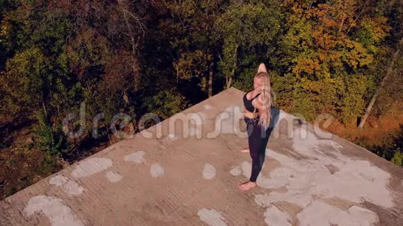 做瑜伽的年轻女人废弃房子的屋顶从上面看从无人机上移走视频的预览图