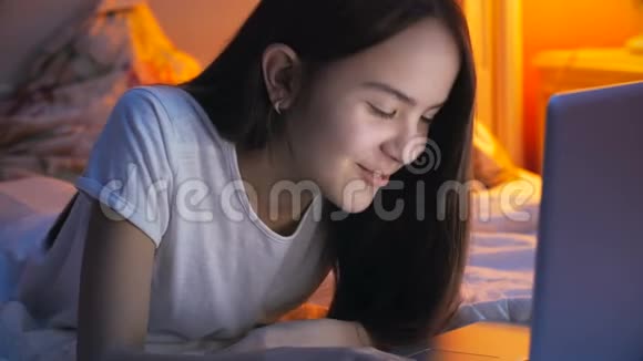 美丽开朗的女孩的肖像通过笔记本电脑上的视频通话服务与朋友交流视频的预览图