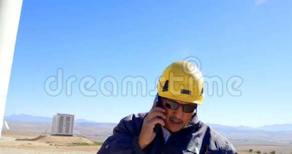男工程师在风电场用手机通话视频的预览图