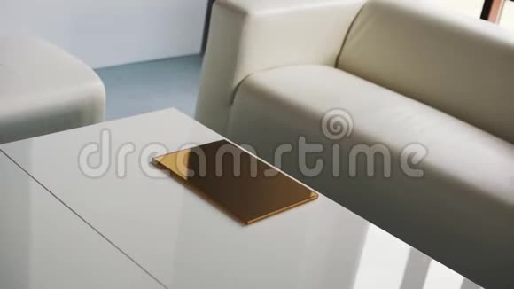 带有白色舒适沙发椅子和带有薄金盒的咖啡桌的轻型客房视频的预览图