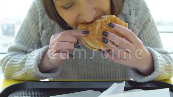 垃圾食品一个黑发女人在快餐店吃汉堡视频的预览图