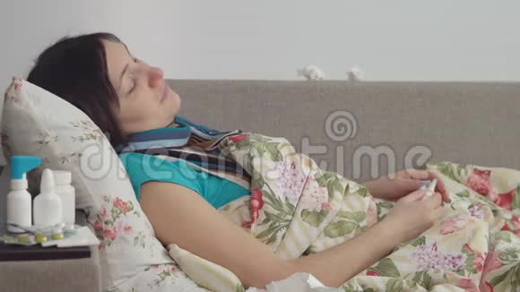 生病的女人躺在家里的床上喷鼻子视频的预览图