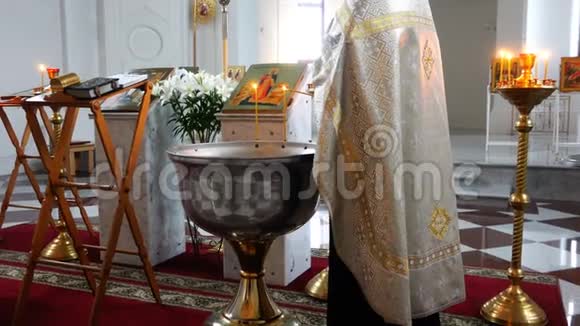 祭司用水把燃着的蜡烛照在字体上作为洗礼的仪式视频的预览图