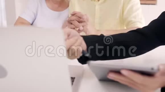 亚洲智能女性代理商通过文件平板电脑和笔记本电脑为老年夫妇提供健康保险老年亚洲夫妇咨询视频的预览图