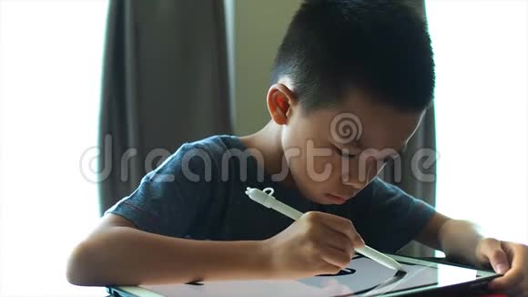 亚洲男孩在数字平板电脑上画画视频的预览图