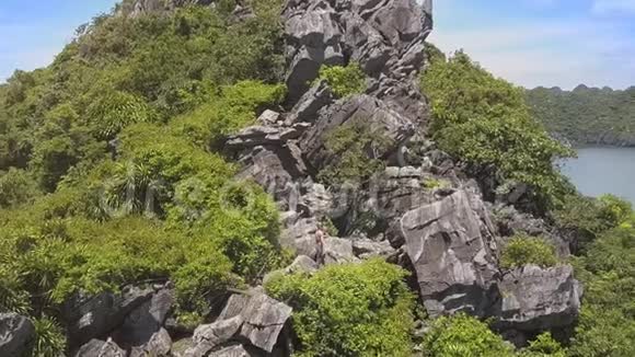Flycam向美丽的洛基岛和石中的女孩移动视频的预览图