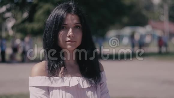 城市街道上模糊的背景上一幅美丽的年轻女子黑发的肖像关门视频的预览图