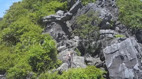 在岛上的石头中间有一个长着马尾辫的女孩视频的预览图