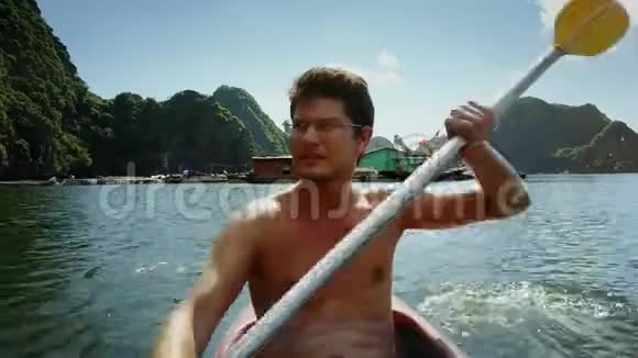 戴眼镜的特写员沿着绿松石湾划独木舟视频的预览图