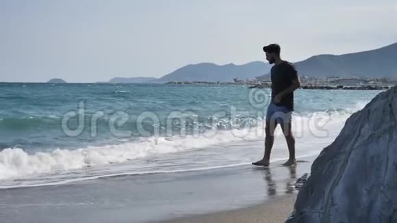 一个年轻人独自在海滩上散步视频的预览图