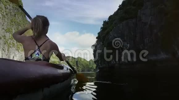 Bikini在陡峭悬崖之间划艇的后景女孩视频的预览图