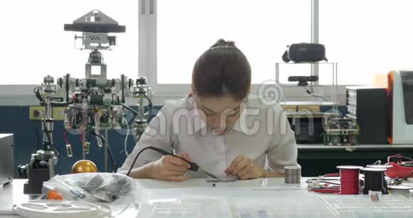 女电子工程师正在她的车间焊接一块电电板视频的预览图