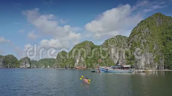 无人机在海中展示船的陡峭悬崖和人在独木舟视频的预览图