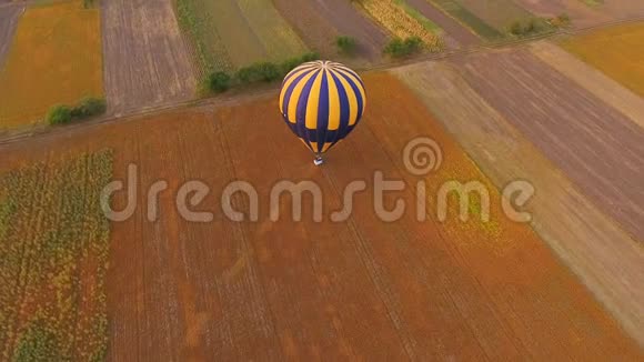 热气球降落在农村村庄和河流的背景空中视频的预览图
