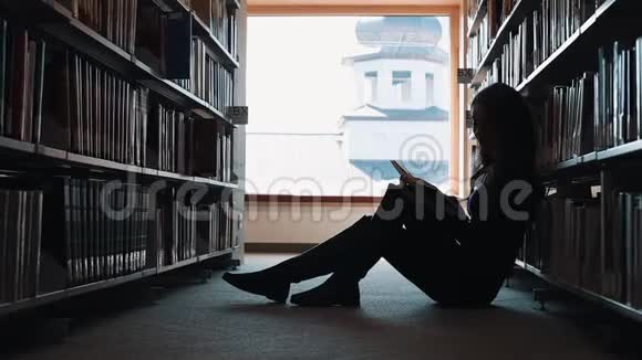 女孩坐在地板上在图书馆看书视频的预览图