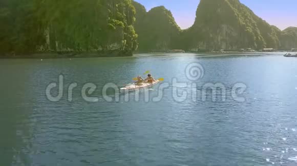 阳光明媚的一天上景男子女孩划桨皮艇视频的预览图