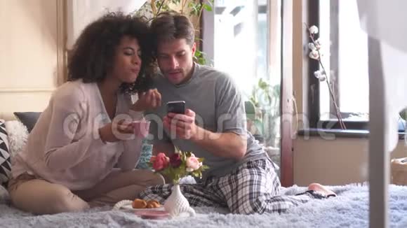 情侣在床上用手机吃早餐视频的预览图