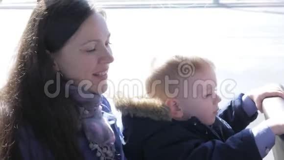 一位年轻的母亲和一个男孩正在坐公共汽车微笑着看着镜头视频的预览图