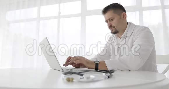 严肃的医生在电脑上工作视频的预览图