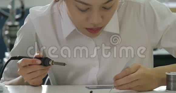 女电子工程师正在她的车间焊接一块电电板视频的预览图