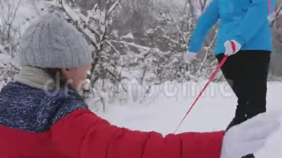 快乐的童年概念家庭寒假孩子和母亲在雪地里雪橇女儿和妈妈在冬天玩视频的预览图
