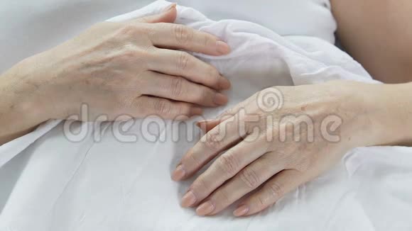躺在床上的老妇人的手皱纹的皮肤衰老的人经验视频的预览图