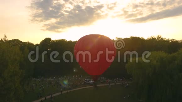 一群人看着红热气球升成阳光灿烂的天空节日视频的预览图