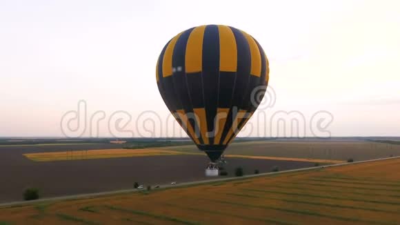 很少有热气球飞过田野道路在田野中奔跑工业化视频的预览图
