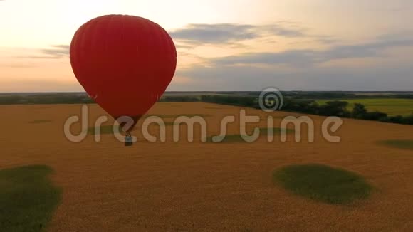 日落时分红热气球飘过田野浪漫的纪念日爱情视频的预览图