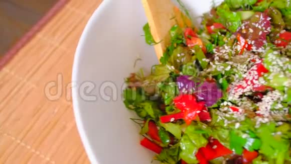 女人搅动一碗新鲜蔬菜沙拉视频的预览图