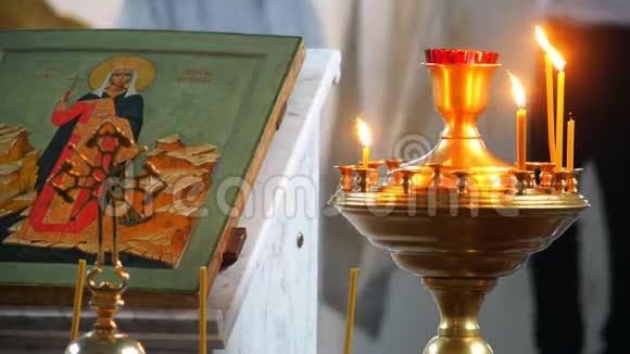 在东正教教堂的图标附近蜡烛燃烧着火焰视频的预览图