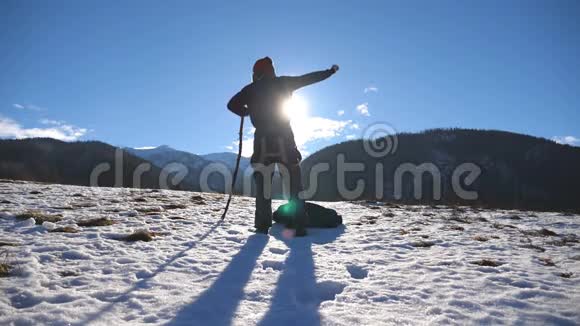 年轻快乐男子的后景在冬天的山上跳舞很有趣在大雪纷飞的背景下跳舞视频的预览图