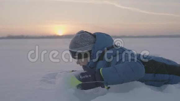 日落时一个孩子在雪地里玩耍新鲜空气中的乐趣和游戏视频的预览图