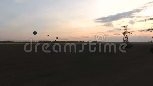 黄昏时分空中气球在田野上飞舞电缆在工业上轰鸣视频的预览图