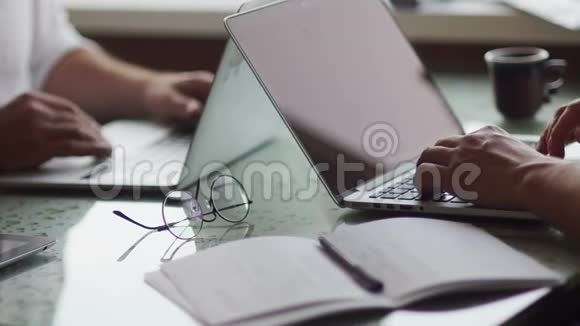 商业概念桌子上有笔记本电脑文件文件眼镜特写镜头伙伴握手视频的预览图