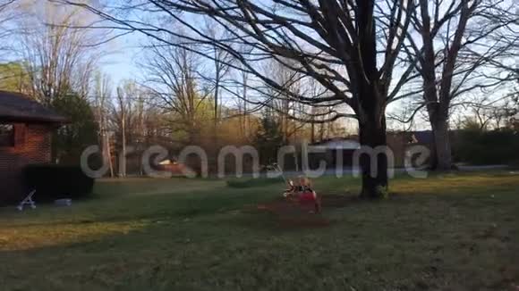 可爱的小男孩在春天公园玩秋千视频的预览图