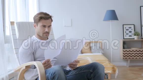 坐在放松的椅子上阅读文件的成年人视频的预览图